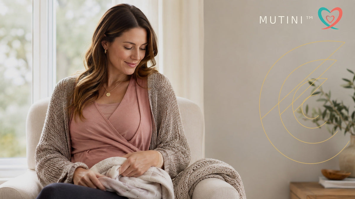 Woman wearing a nursing-friendly top with MUTINI double-heart logo and golden Fibonacci design