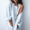Woman wearing the MUTINI light blue striped maternity robe, front close-up